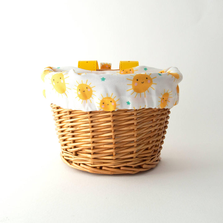 Woven bike basket with cheerful sun print liner, perfect for beach days and outdoor adventures