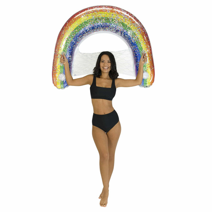 Woman holding glittery rainbow inflatable pool float, perfect for beach days and summer adventures