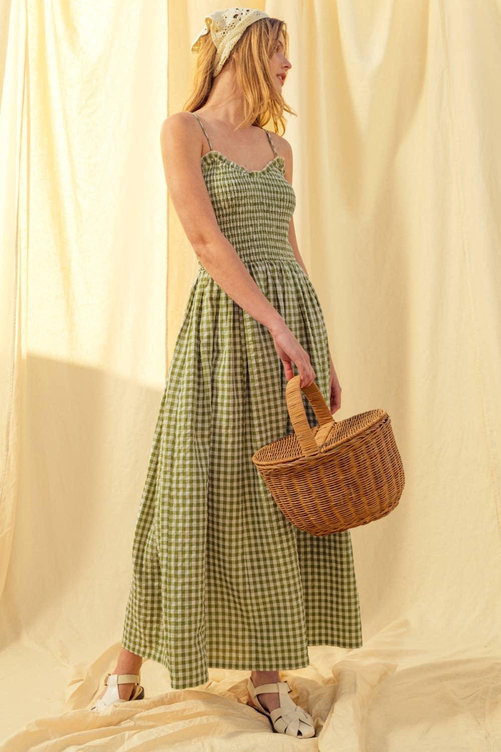 Woman in green gingham maxi dress with wicker basket, cream headscarf, and sandals