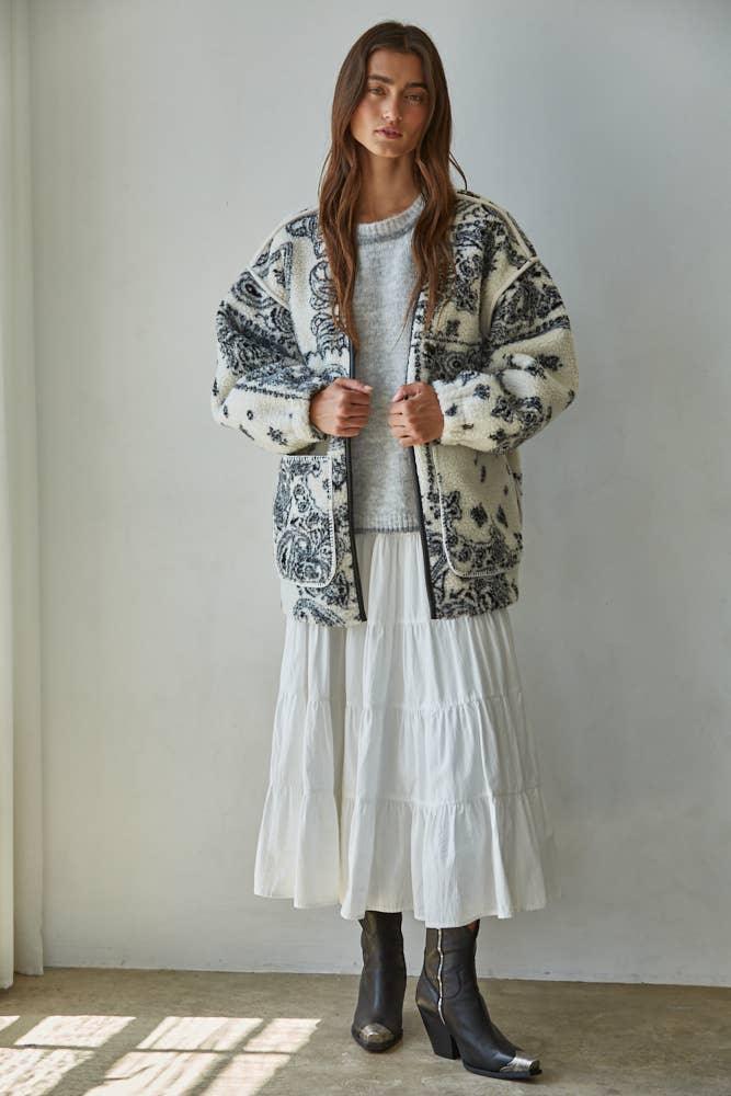 Cozy patterned fleece jacket with tiered white skirt and black boots for coastal PNW style