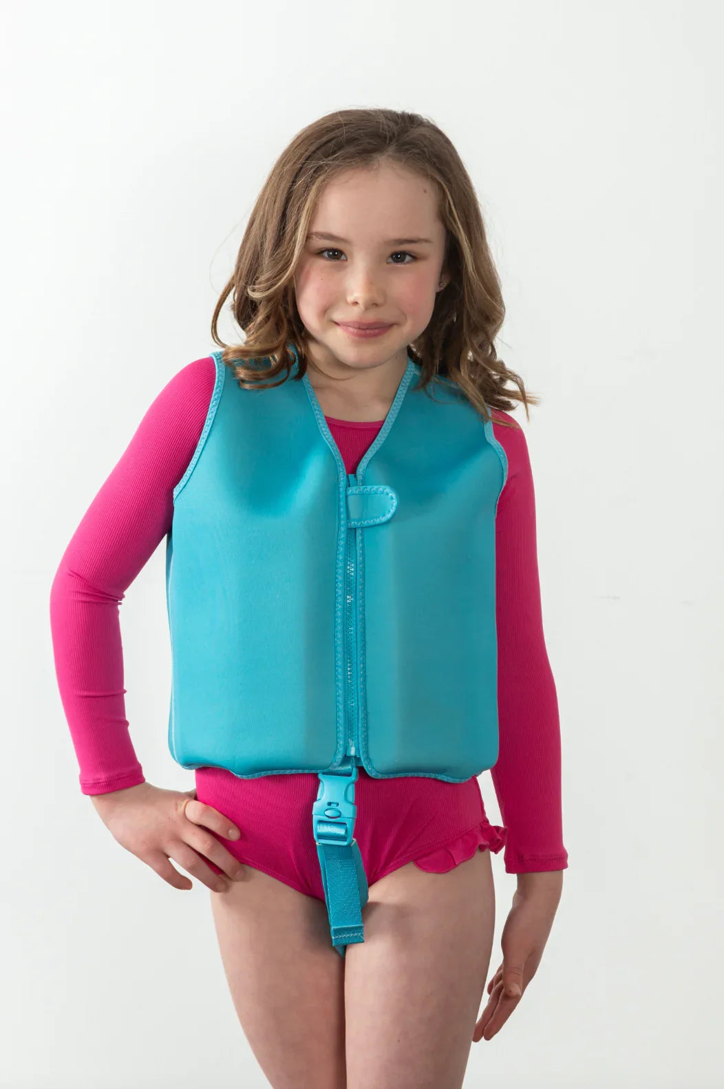 Child wearing turquoise swim vest with pink rash guard and swim shorts