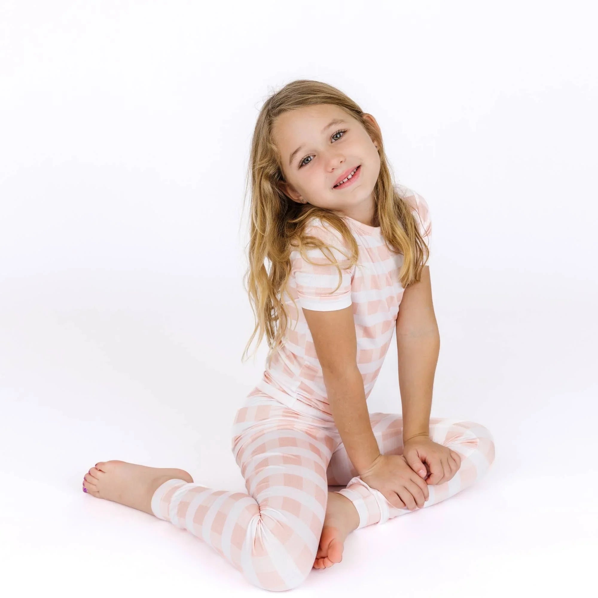 Girl in pink and white gingham pajama set, cozy kids sleepwear for bedtime comfort