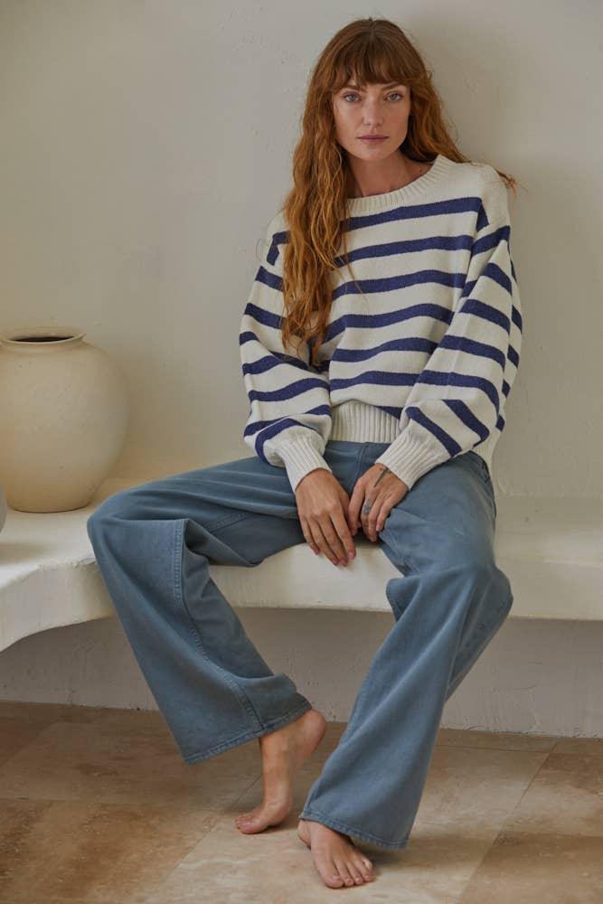 Woman in cozy striped sweater and wide-leg jeans, coastal style outfit for PNW adventures