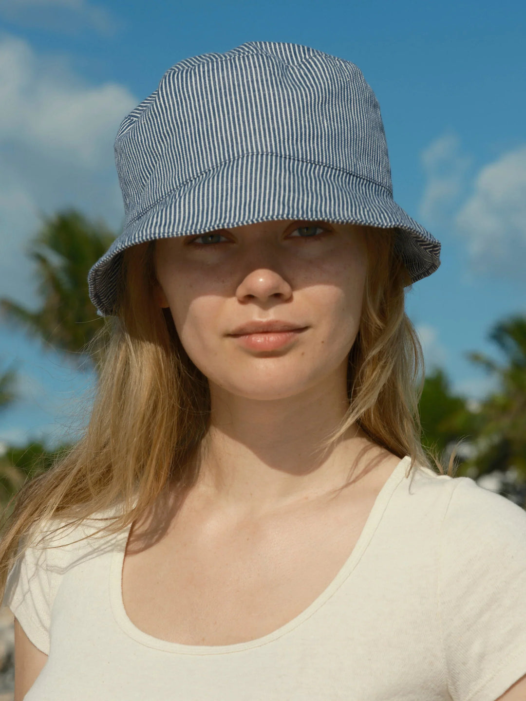 Blue and white striped bucket hat for sunny beach days and coastal adventures