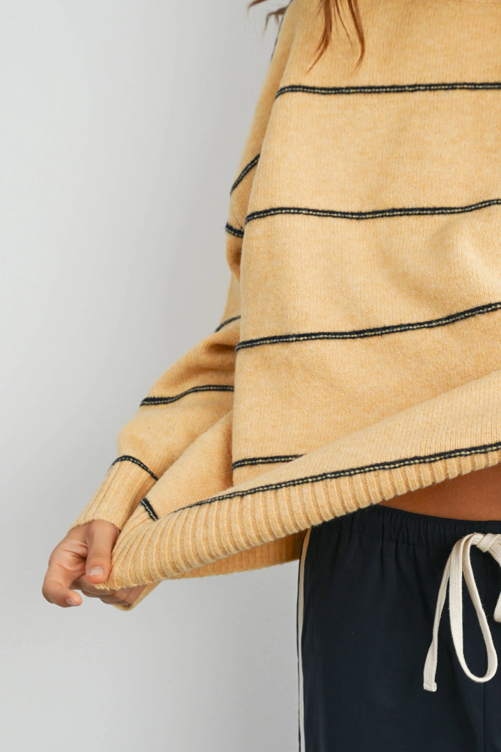 Mustard yellow ribbed knit sweater with black contrast stitching, paired with navy drawstring pants for coastal style.