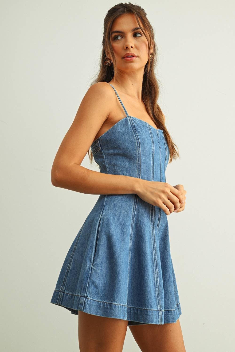 Woman wearing blue denim mini dress with thin straps and flared skirt
