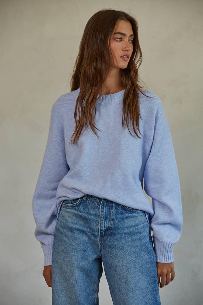 Light blue cozy sweater paired with high-waisted denim jeans for casual coastal style