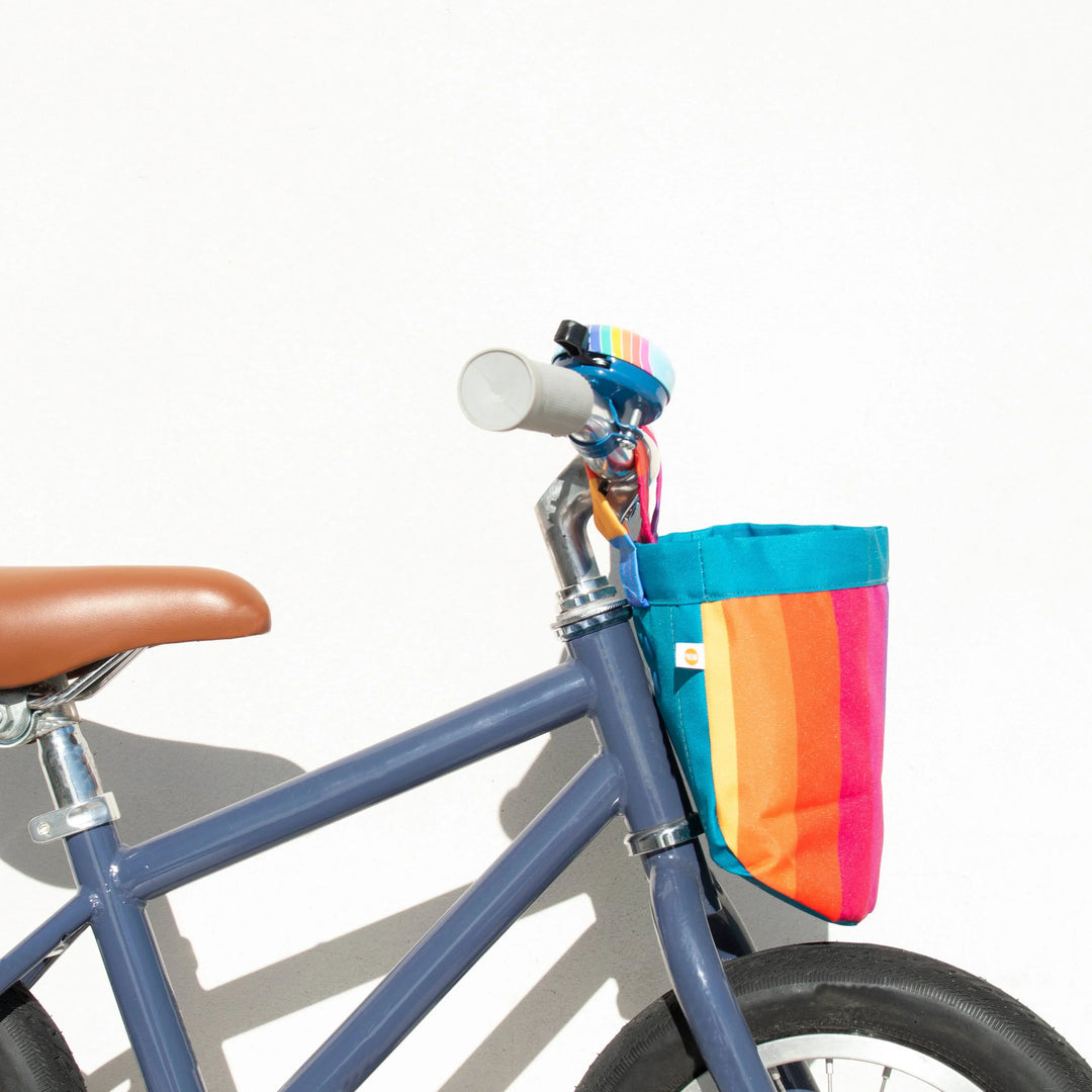 Blue bike with rainbow stripe bag and bell, perfect for coastal rides and PNW adventures.