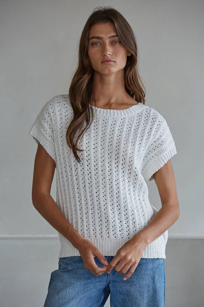 White knit short sleeve top with ribbed texture, styled with blue jeans for coastal casual wear