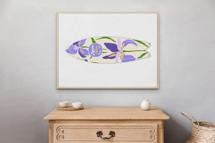 Framed surfboard art print with purple floral design, displayed above wooden console table in modern home decor