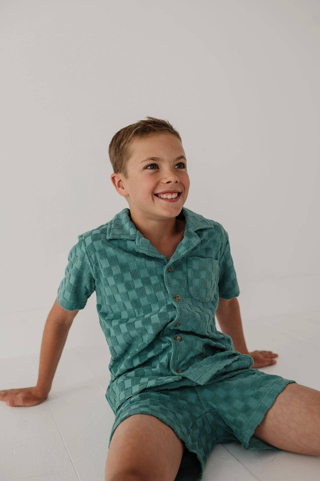 Boy in teal checkered short sleeve shirt and shorts set, coastal style kids outfit