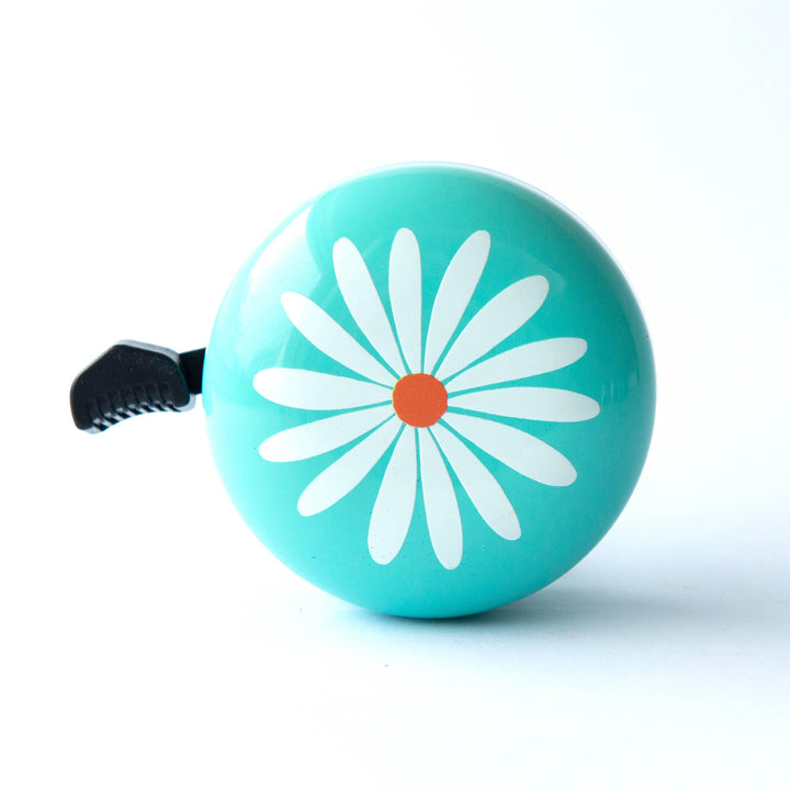 Turquoise bike bell with white daisy flower design and black lever for cycling adventures