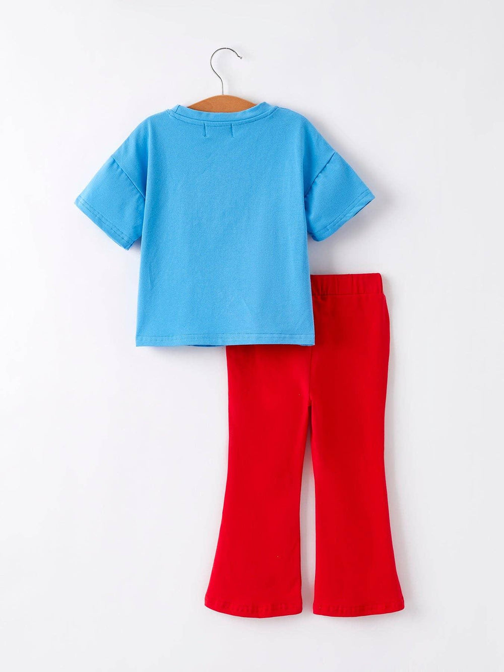 Blue kids tee and red flared pants set on hanger, casual coastal outfit for playdays