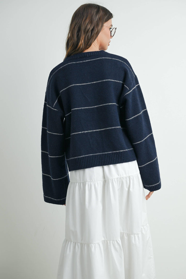 Navy blue striped knit sweater with white trim, paired with white tiered skirt, coastal style outfit