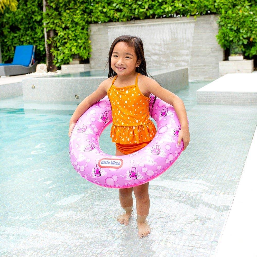 Little Tikes pink inflatable swim ring with car print, held by child in pool, perfect for pool fun