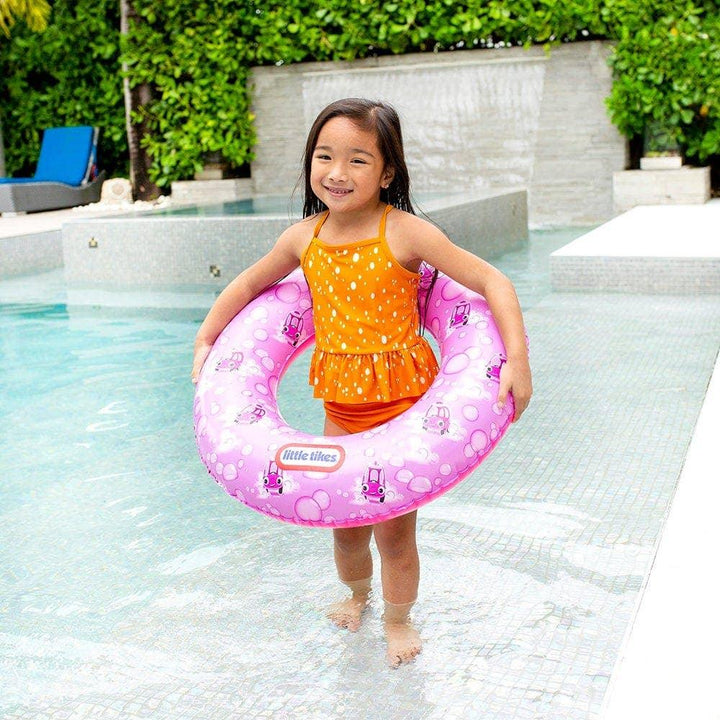 Little Tikes pink inflatable swim ring with car print, held by child in pool, perfect for pool fun