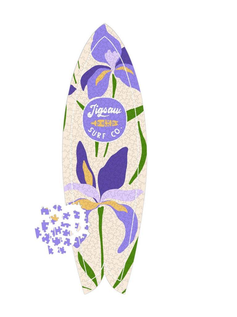 Floral surfboard jigsaw puzzle with purple irises and green leaves, incomplete pieces scattered