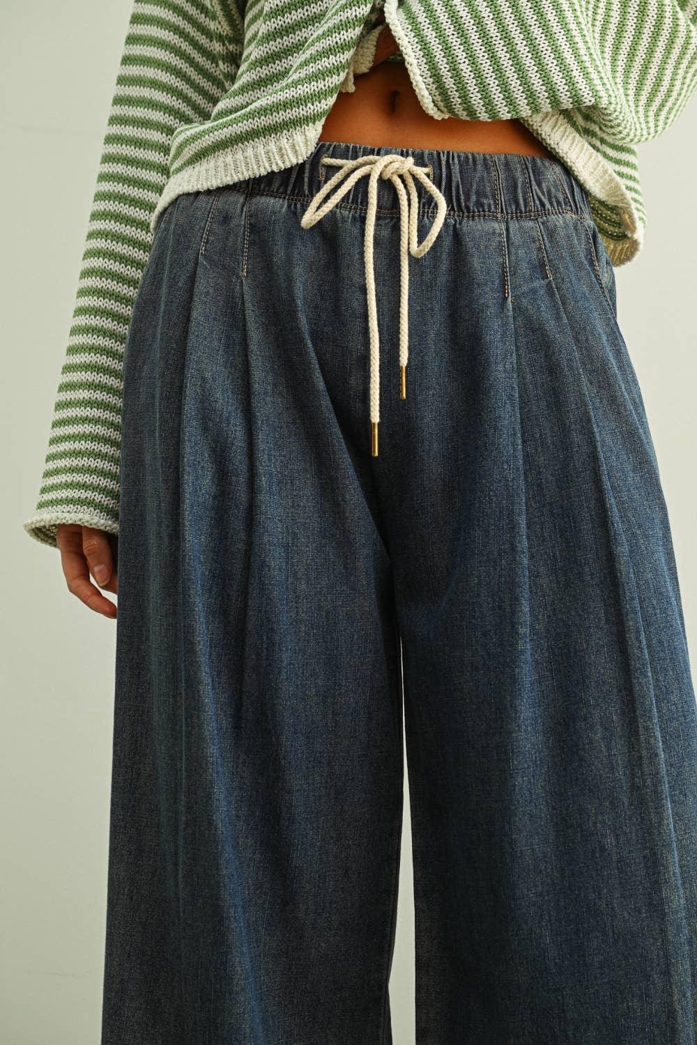 Wide-leg denim pants with drawstring waist, paired with green striped knit top