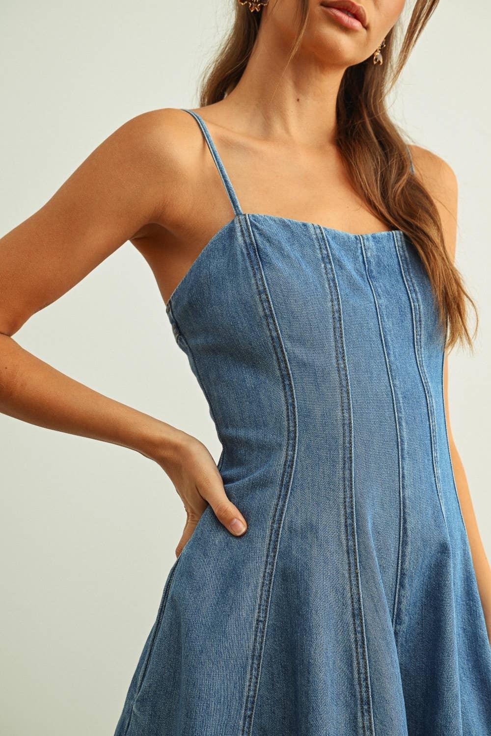 Woman in blue denim sundress with thin straps and front seams, casual summer style