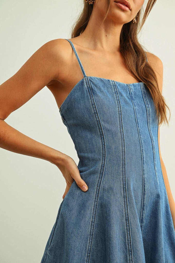 Blue denim sundress with thin straps and front seams, perfect for coastal weekends and outdoor adventures.
