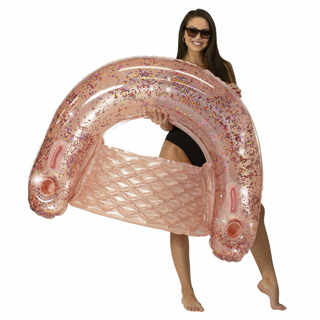 Woman holding pink glitter inflatable pool float with wave texture, perfect for beach days and summer fun.