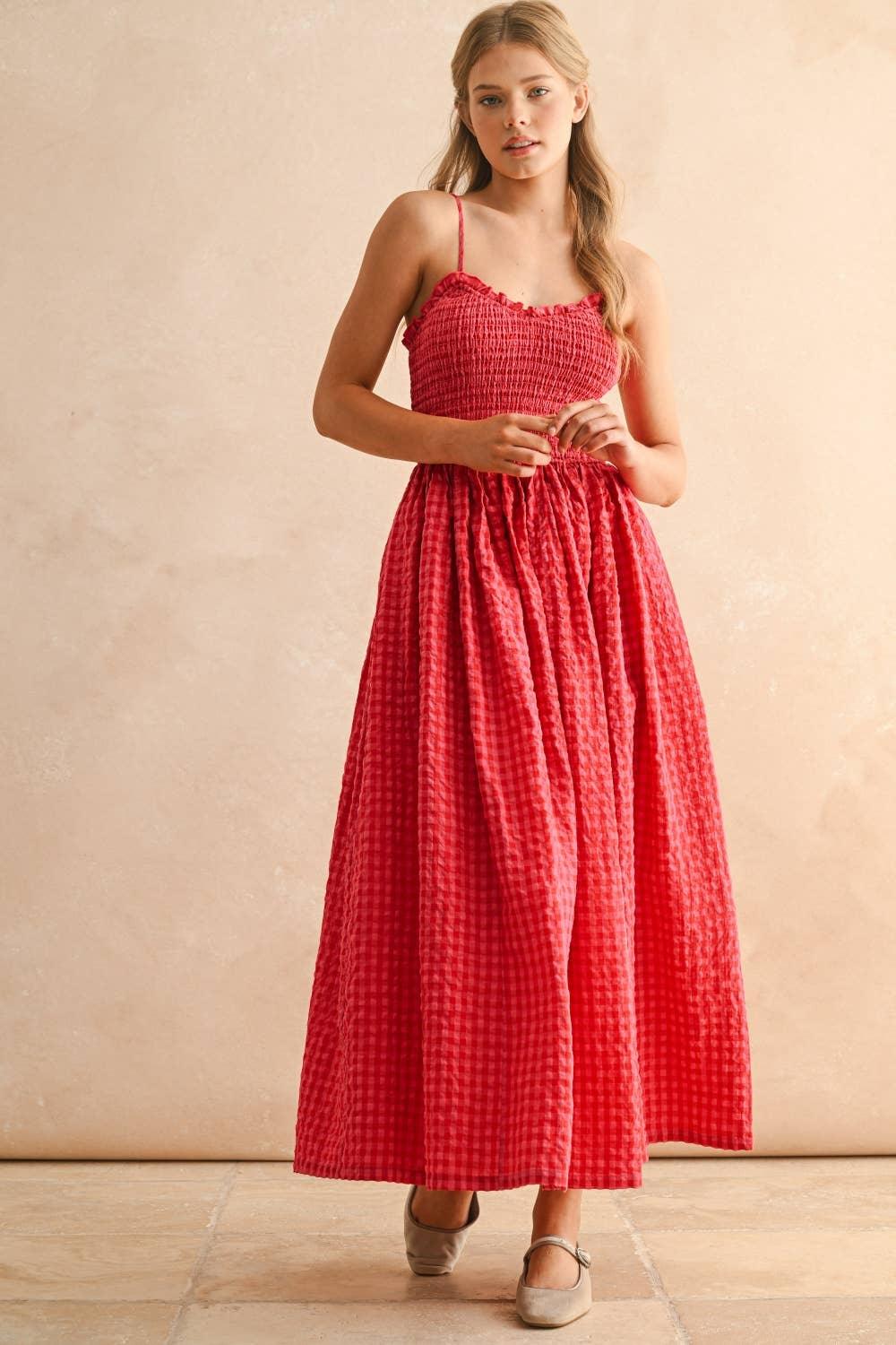 Red gingham maxi dress with smocked bodice and spaghetti straps, paired with beige flats.