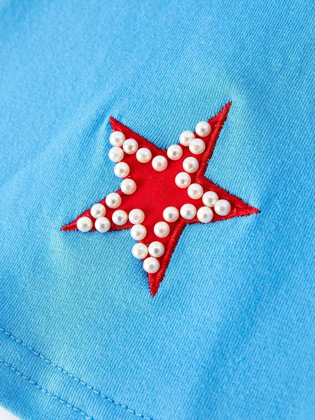Light blue shirt with red star and pearl embellishments, coastal style apparel