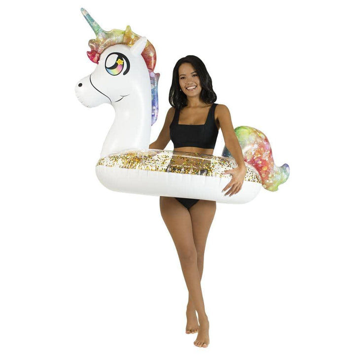 Woman holding unicorn pool float with glittery gold base and rainbow mane for beach or pool fun