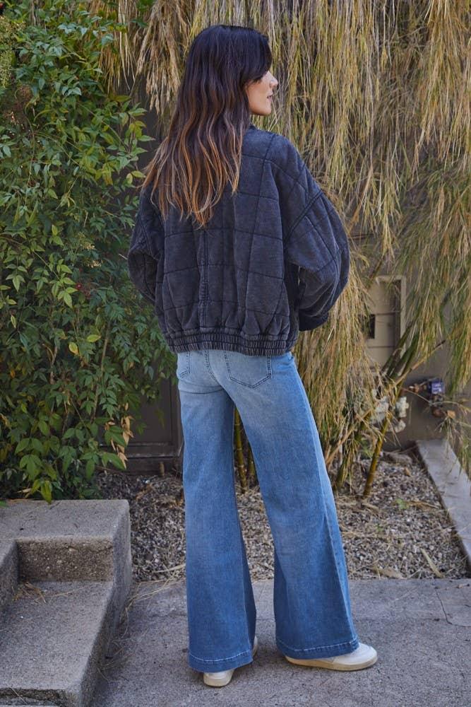 Woman in quilted jacket and wide-leg jeans, coastal outdoor style