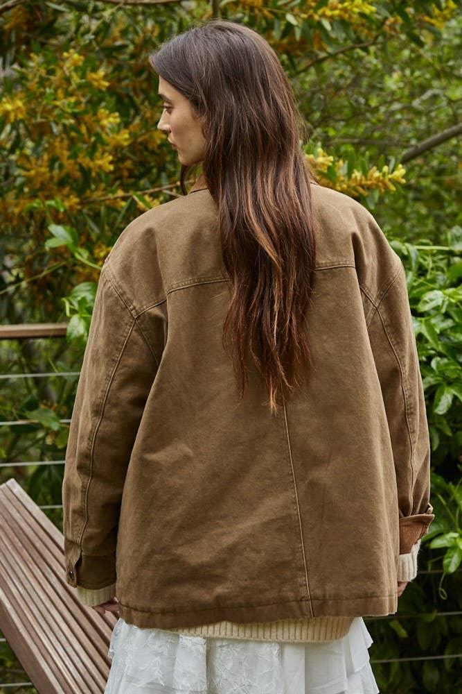 Woman wearing olive utility jacket outdoors, coastal PNW style for beach days and trail adventures