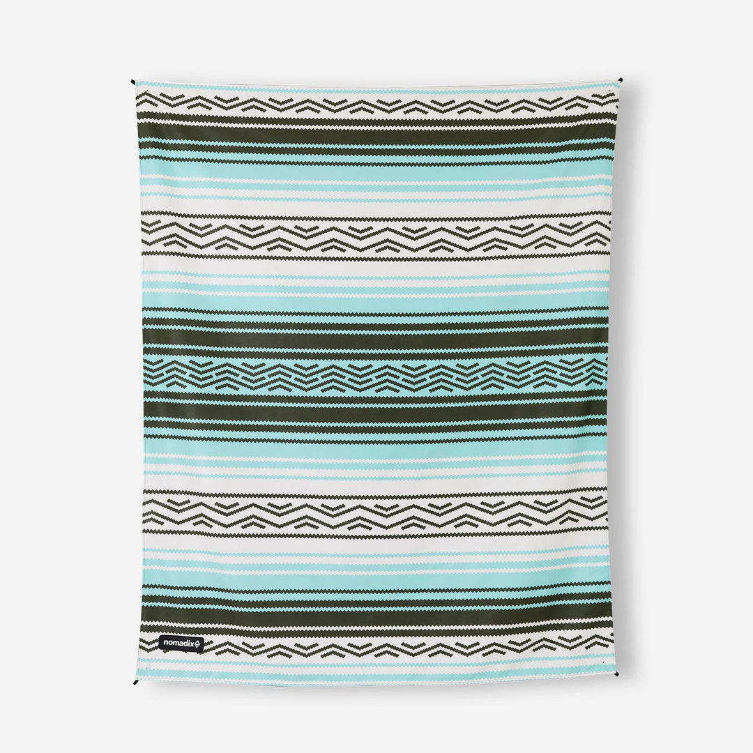Nomadix beach towel with teal, white, and olive geometric stripes for outdoor adventures and coastal style