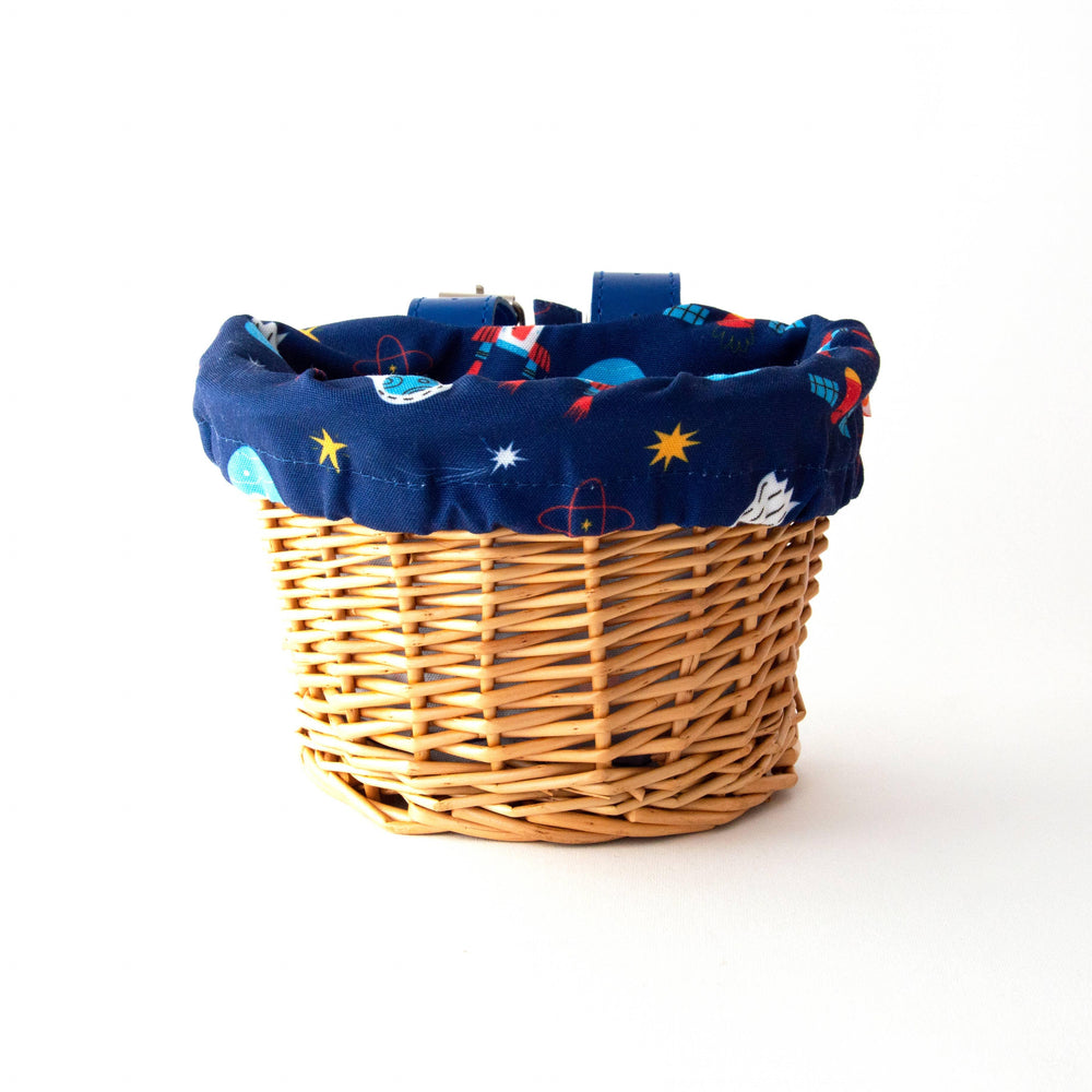 Woven bike basket with space-themed liner, perfect for coastal adventures and everyday rides.
