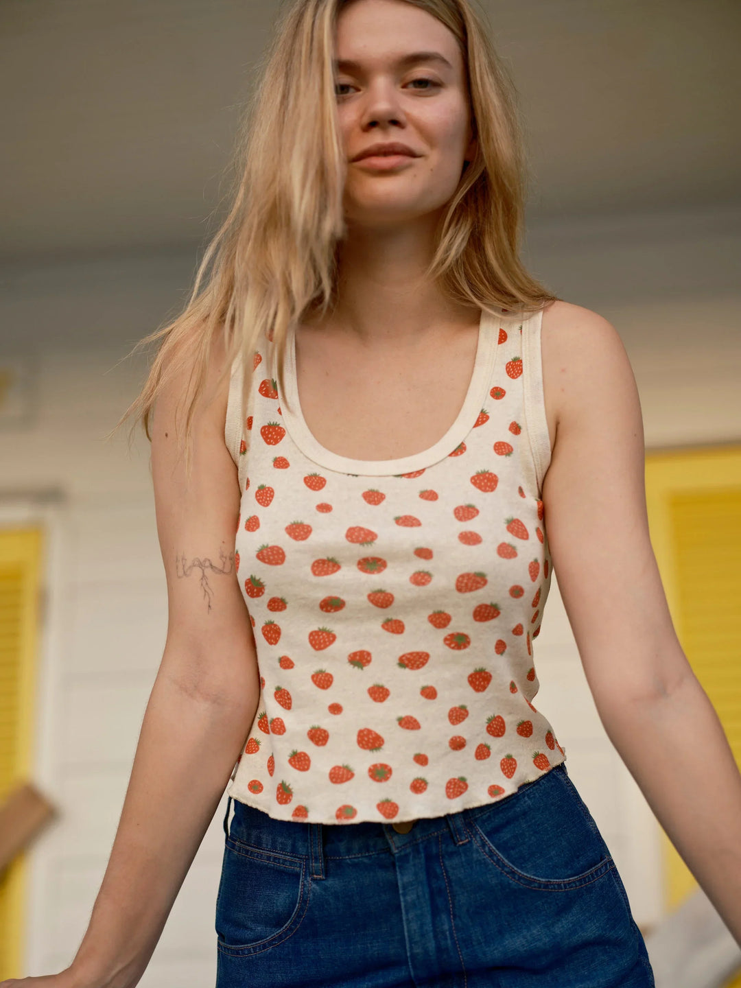 Woman in strawberry print tank top and denim shorts, coastal PNW style