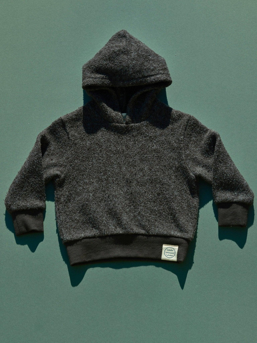 Cozy kids' charcoal fleece hoodie with wave logo, perfect for PNW outdoor adventures and coastal style.