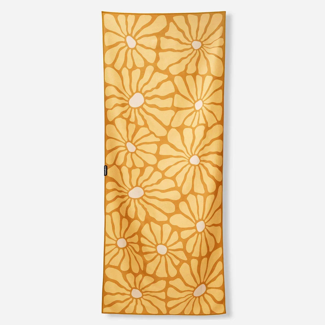 Mustard yellow beach towel with white daisy pattern, perfect for coastal adventures and outdoor lifestyle