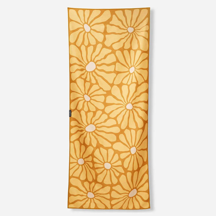 Mustard yellow beach towel with white daisy pattern, perfect for coastal adventures and outdoor lifestyle