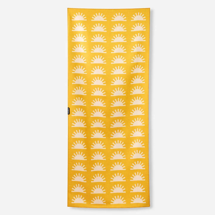 Mustard yellow beach towel with white sunburst pattern, perfect for coastal adventures and outdoor weekends.
