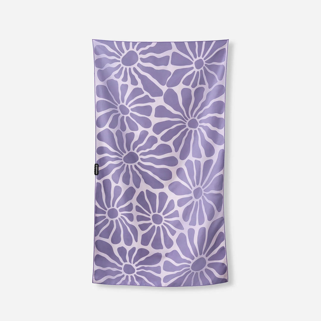 Purple floral patterned towel with white accents, ideal for beach or pool use.