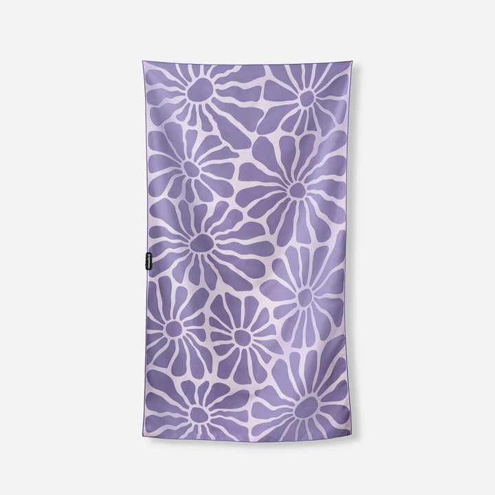 Purple floral patterned towel with white accents, ideal for beach or pool use.
